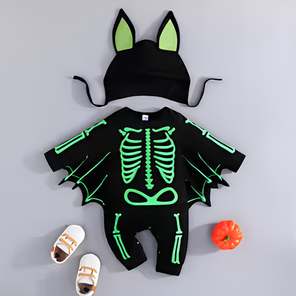 Glow Skeleton style: black baby romper with a bright green glow-effect bone print across the chest and legs, shown with the matching bat hat that comes with it