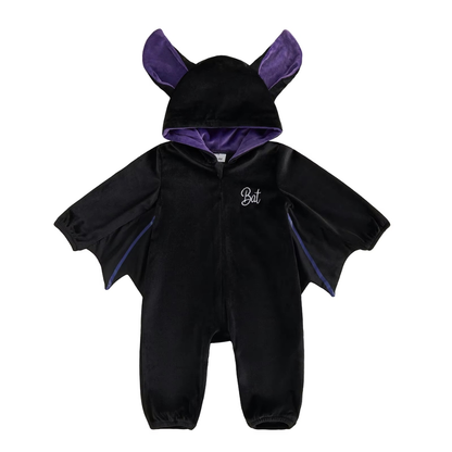The Lunaby Bat Suit seen from the front: black velvet baby romper with a purple-lined hood, stand-up bat ears, scalloped wing sleeves, full-length front zip and Bat script embroidery