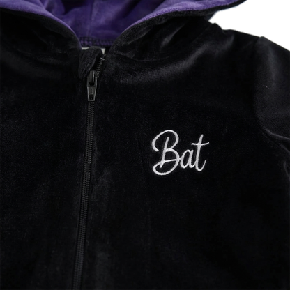 Close-up of the embroidered Bat script on the chest beside the full-length zipper with its covered pull